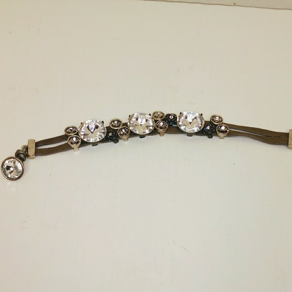 Fossil lesther bracelet with clear crystals.